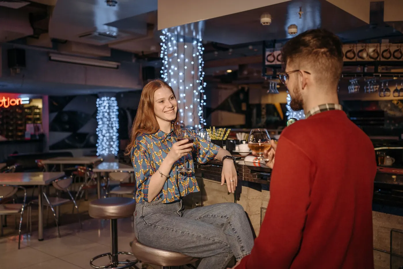 Two friends having a one-to-one conversation over drinks at a bar