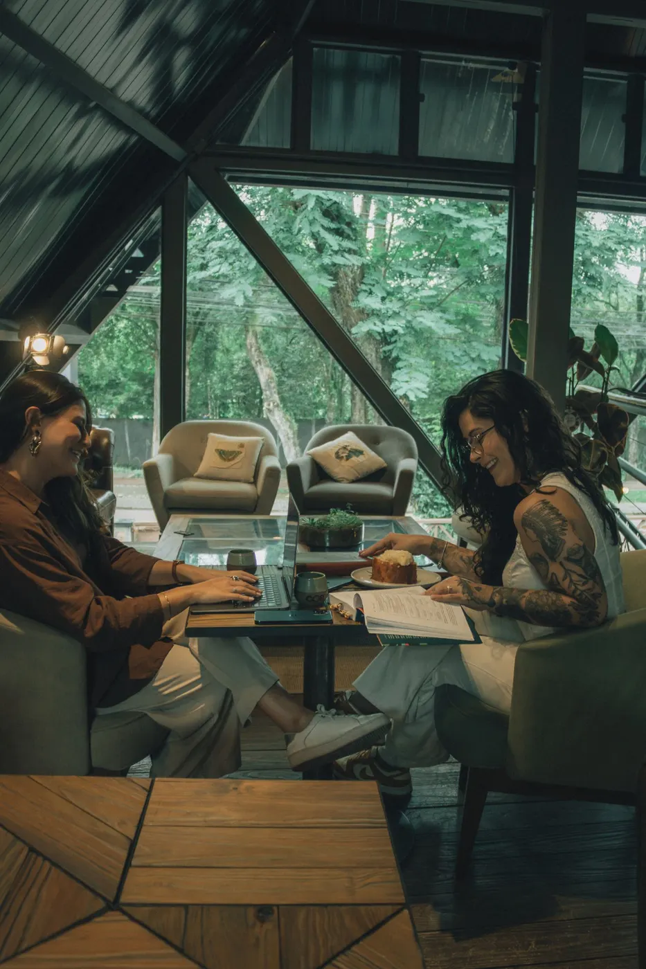 Two friends chatting one-to-one in a quiet glass cabin café